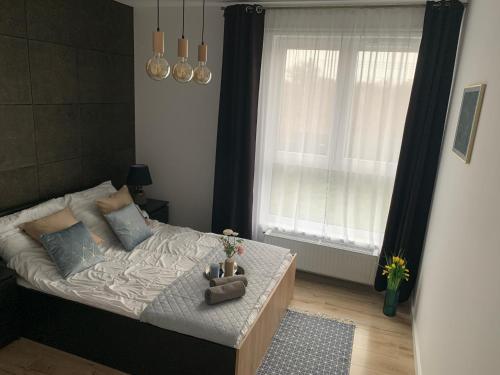 a bedroom with a bed and a window at Blu Apartament 6 Cetniewo Osada in Władysławowo