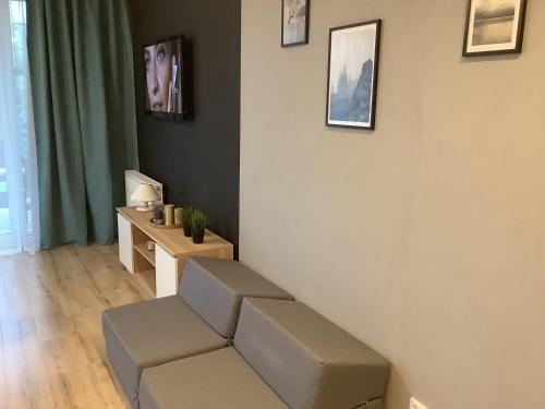 a living room with a couch and a desk at Blu Apartament 6 Cetniewo Osada in Władysławowo