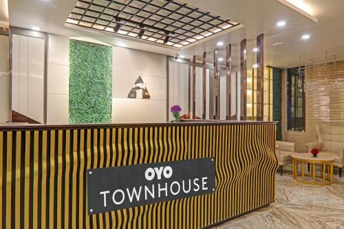 a lobby with a yellow and black sign on a counter at Super Townhouse Hotel Impact in Lucknow
