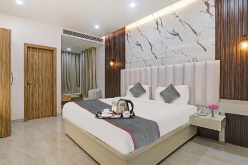a bedroom with a large white bed with a tray on it at Super Townhouse 1149 Hotel Impact in Chinhat