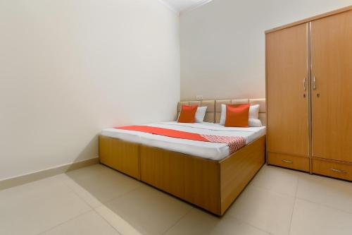 a small bed with orange pillows in a bedroom at OYO Sabtera Homes in Kharar