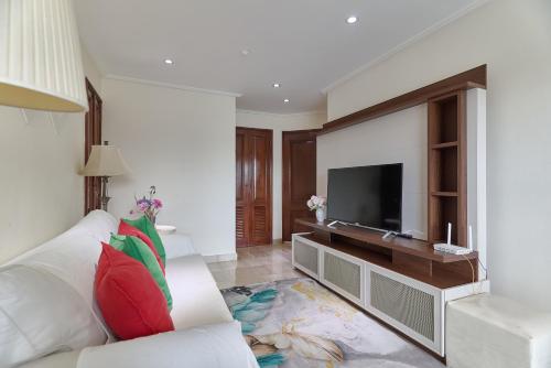 a living room with a white couch and a flat screen tv at Exquisite Oceanfront Suite in Santo Domingo