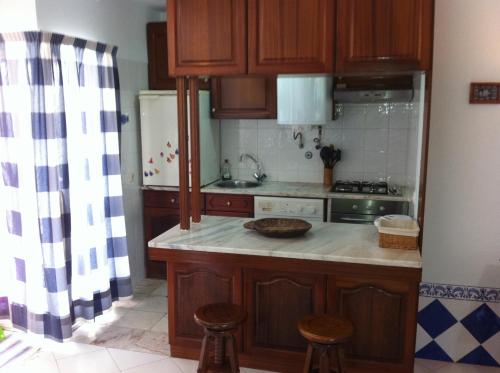 cocina con armarios de madera y horno con fogones en Apartamento Navegantes, en Sintra