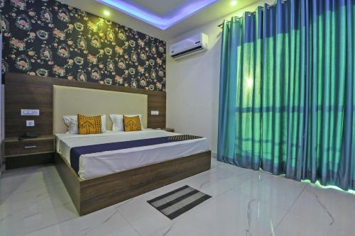 a bedroom with a bed and a green curtain at SPOT ON Hotel White Rose in Zirakpur