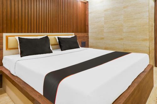 1 dormitorio con 1 cama blanca grande y paredes de madera en Hotel Keys Elite, en Vijayawāda