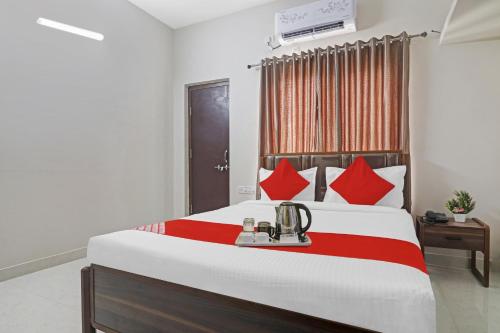 Qualia Homes Kondapur في Kondapur: غرفة نوم بسرير كبير ومخدات حمراء