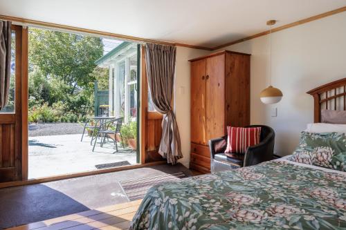 a bedroom with a bed and a sliding glass door at History @ Renall in Masterton