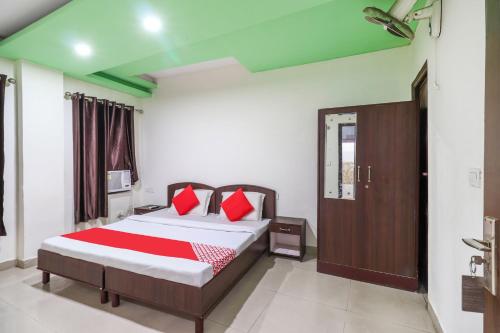 Un dormitorio con una cama con almohadas rojas. en OYO Flagship 62748 Hotel Zeenat, en Jammu