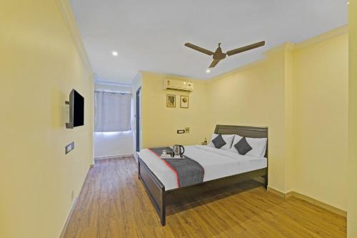 a bedroom with a bed with a ceiling fan at Townhouse Fantasea Hotels Near OMR in Chennai