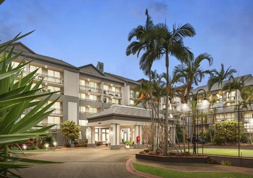 an exterior view of a hotel with palm trees at Paradise Island Resort Surfers Paradise - Garden Suite in Gold Coast
