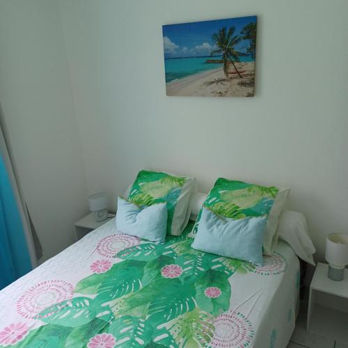 a bedroom with a bed with a palm tree at L IXORA VOUS ACCEUILLE in Sainte-Luce