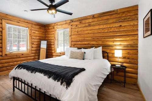 1 dormitorio con 1 cama con paredes de madera y techo en Pine Loop Log Cabin, en La Pine