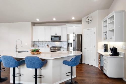 a kitchen with white cabinets and blue bar stools at HomeAway Vacation Rental - Eagle Crest - Meredith Lodging in Redmond