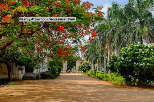 una calle arbolada con flores rojas y árboles en Hotel O Sree Radha Lodge Near Snow World, en Hyderabad