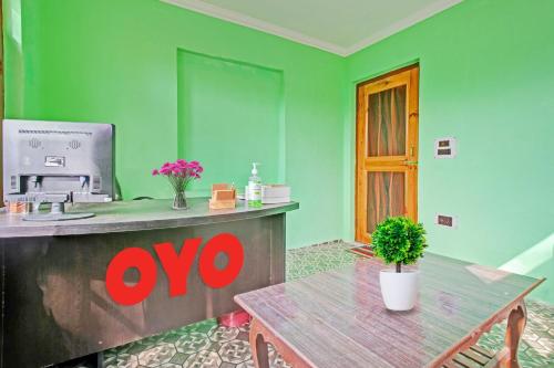 ein grünes Zimmer mit einem Holztisch und einer Kaffeebar in der Unterkunft OYO Green Resort in Gandbal