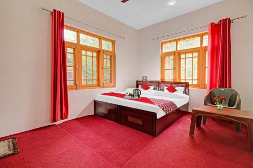 een slaapkamer met een bed en een rood tapijt bij OYO Green Resort in Gandbal
