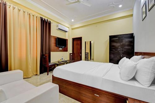 a hotel room with a large bed and a desk at Collection O Hotel Shri Ganesh in Jaipur