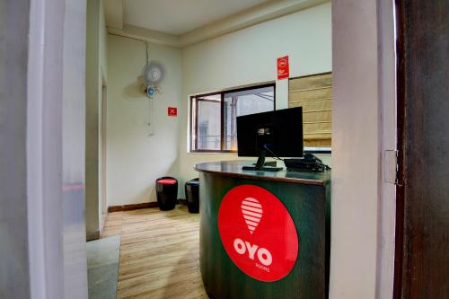 an office with a desk with a sign on it at OYO Flagship Maple The Residence Near RDB Cinemas in Thākurdwari