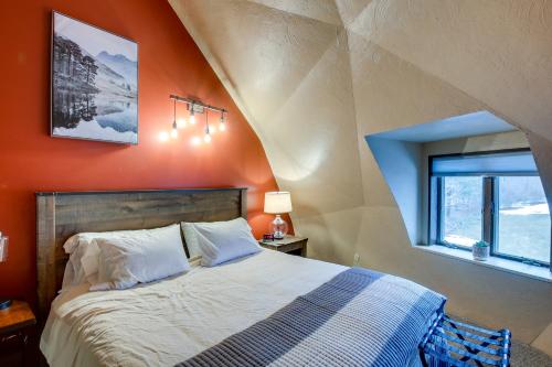 a bed in a room with an orange wall at Wisconsin Vacation Rental 1 Mi to Road America! in Plymouth
