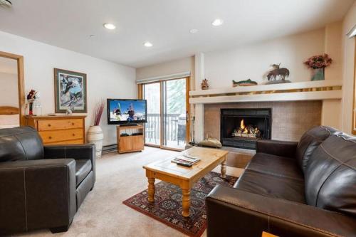 a living room with a couch and a fireplace at Townsend Place Ski In Ski Out Access in Beaver Creek