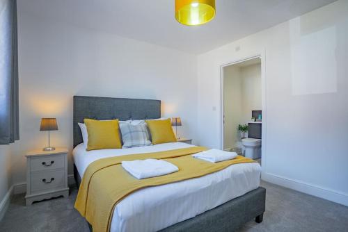 a bedroom with a large bed with yellow pillows at Stylish New Bungalow - Ideal for up to 10 in Welney