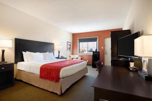 ジレットにあるRed Lion Hotel Gilletteの大きなベッドとデスクが備わるホテルルームです。