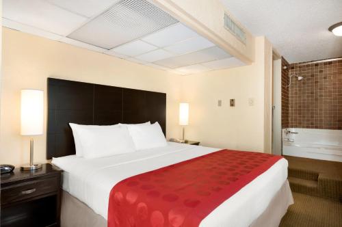 a hotel room with a large bed with a red blanket at Red Lion Hotel Gillette in Gillette