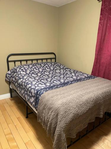 Schlafzimmer mit einem Bett mit einer blauen und weißen Bettdecke in der Unterkunft Lemon Tree Inn in Fort McMurray