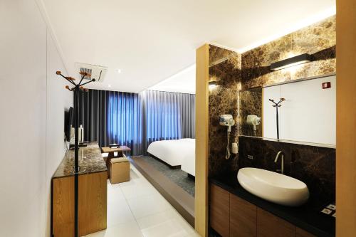 a bathroom with a sink and a bed in a room at Incheon Wolmido Dubai Tourist Hotel in Incheon