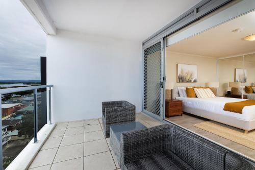 a bedroom with a bed and a balcony at The Crest Penthouse 902 in Forster