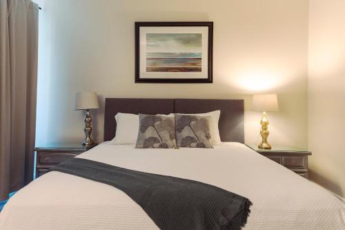 een slaapkamer met een groot bed met 2 nachtkastjes bij Maple Rise Guesthouse in Duncan