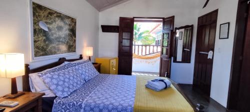 a bedroom with a bed with a blue comforter at Casa Sal in Paraty