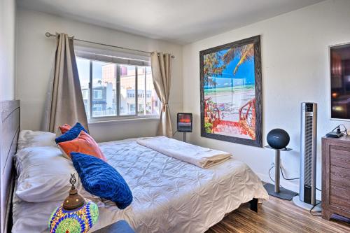 a bedroom with a bed with blue pillows and a window at Newport Beach Vacation Rental - Short Walk to Pier in Newport Beach
