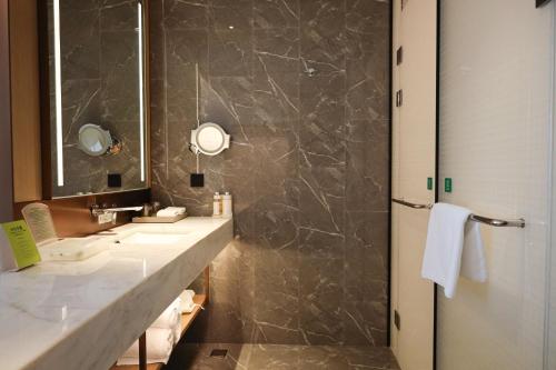 a bathroom with two sinks and a mirror at Holiday Inn Fuyang by IHG in Fuyang
