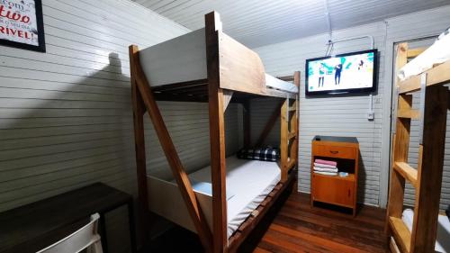 a room with two bunk beds and a tv at Pousada Recriare in Campo Mourão
