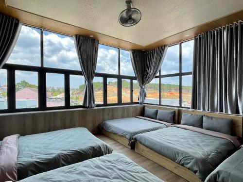 een kamer met 2 bedden en een groot raam bij Tuan Long Da Lat Hostel in Da Lat