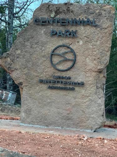 a sign that says centennial park on a tree stump at Regency 7 Motel in Fayetteville