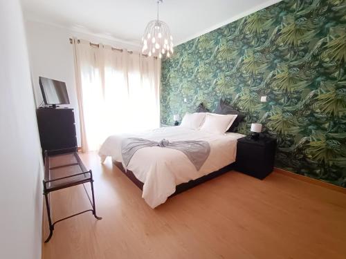 a bedroom with a large bed with a green wallpaper at Stylish 1br in Gaia near Porto, sleeps 4 in Vila Nova de Gaia