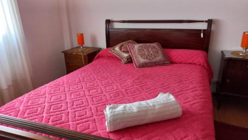 1 dormitorio con cama rosa y almohada en Departamento para vacacionar en Mar del Plata