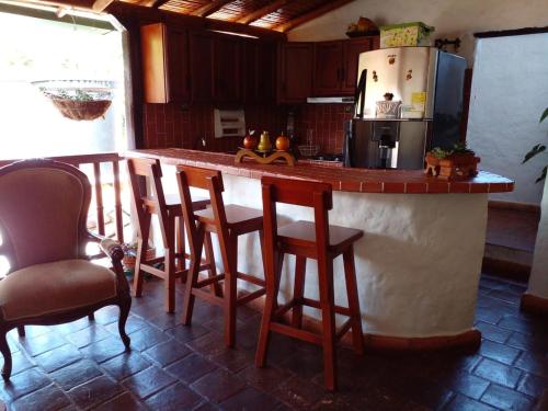 kuchnia z barem z krzesłami i lodówką w obiekcie Mi Casa en Barichara w mieście Barichara