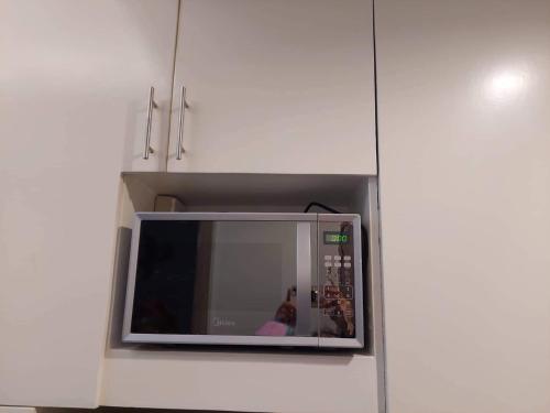 a microwave in a kitchen with a person in it at Coast Residence 4026 PENTHOUSE 1 Bedroom Condo with Wifi & Netflix in Manila