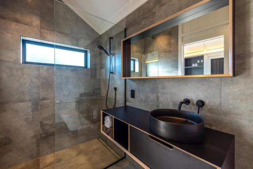 uma casa de banho com um lavatório e um chuveiro em Whare Iti em Blackpool