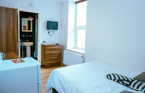 a bedroom with a bed and a sink and a television at 412B Westgate Room 4 in Elswick