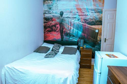 a bedroom with a bed with a painting on the wall at 412B Westgate Room 4 in Elswick
