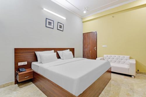 a bedroom with a large white bed and a couch at Collection O Hotel Shri Ganesh in Jaipur