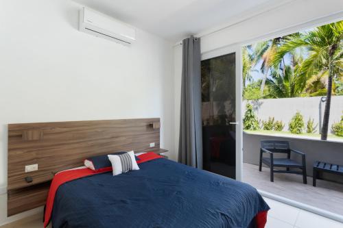 a bedroom with a blue bed and a large window at Beach front Blue Summer Apartment Costa Del Sol in El Zapote