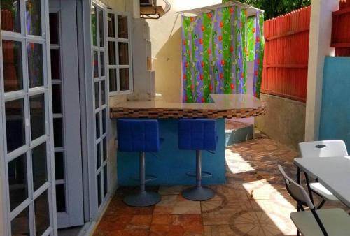 uma cozinha com dois bancos azuis no balcão em Comfort Suites - Special em Choiseul