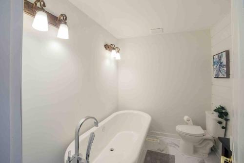 La salle de bains est pourvue d'une baignoire, de toilettes et de lumières. dans l'établissement Awesome family vacation home in Bragg Creek, à Bragg Creek