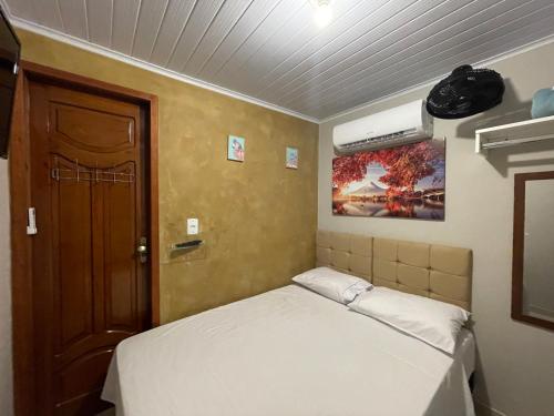 a small room with a bed and a door at Casa Galaxy in Boa Vista