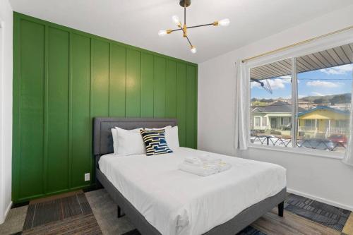 a bedroom with green walls and a bed with a window at Stylish Green & Gold 2BR / 1Bath Apartment in SFO in South San Francisco